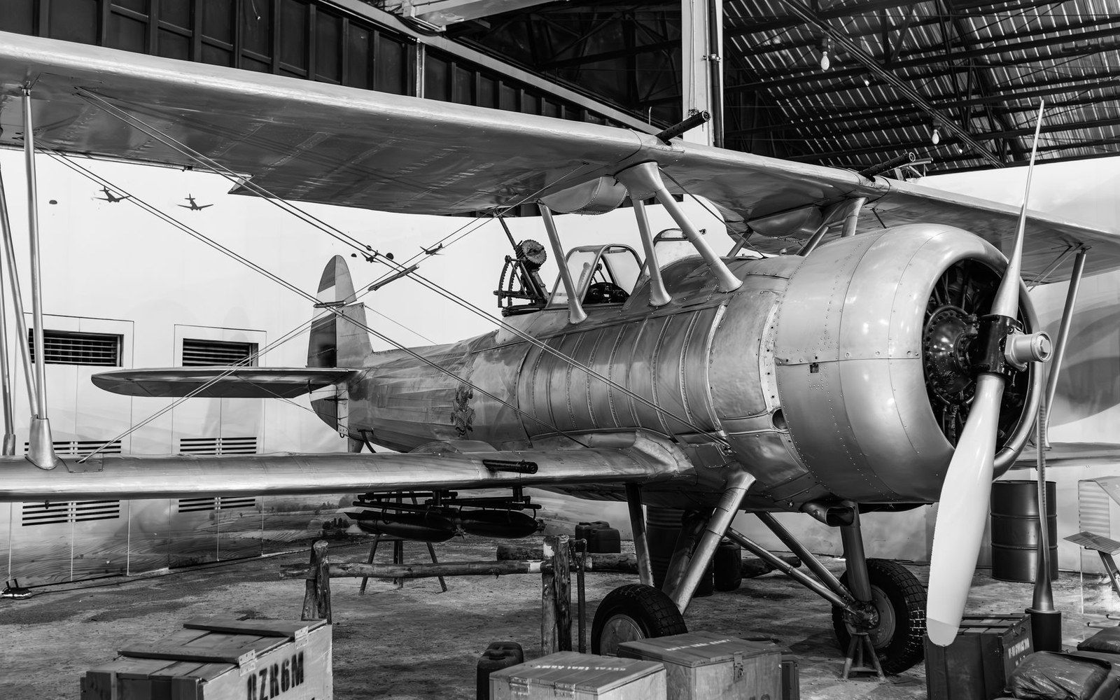 A Troy-built WACO biplane inside the WACO Air Museum hangar, an adult standing beside the lower wing so the wingspan reads at scale